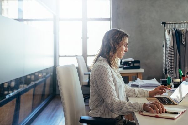 how a firewall protects small businesses woman business owner working on laptop